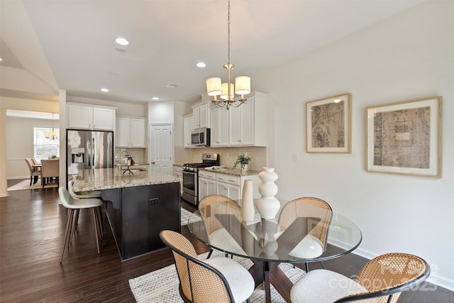 dining area with dark hardwood / wood-style floors and a chandelier