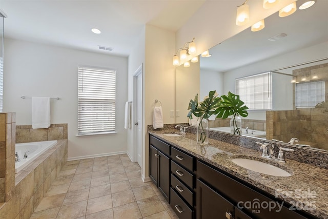 bathroom featuring vanity, tiled bath, and tile patterned floors