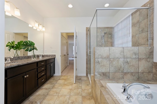 bathroom with vanity and shower with separate bathtub