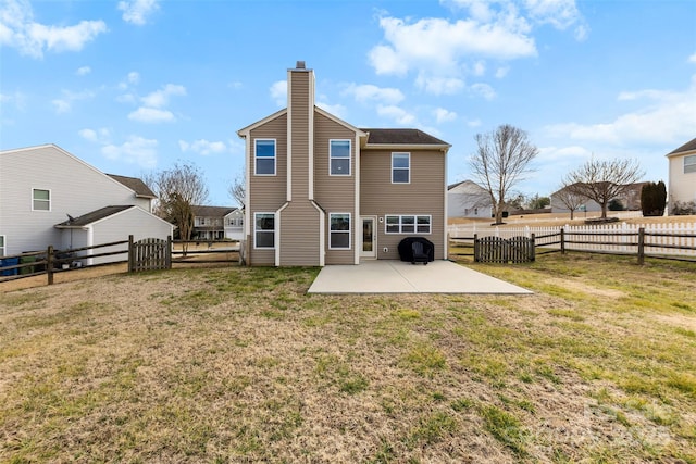 back of property with a lawn and a patio area