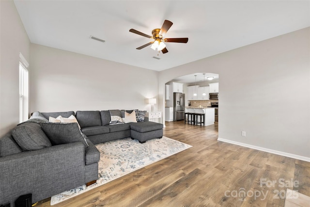 living room with wood-type flooring and ceiling fan