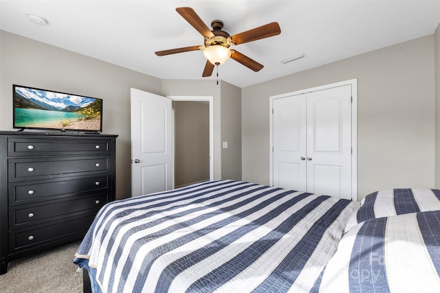 bedroom featuring light colored carpet, a closet, and ceiling fan