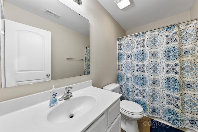 bathroom with hardwood / wood-style flooring, vanity, and toilet