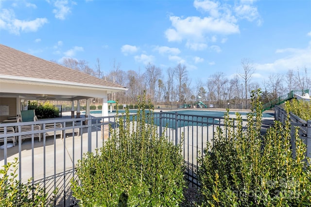 view of swimming pool featuring ceiling fan and a patio area