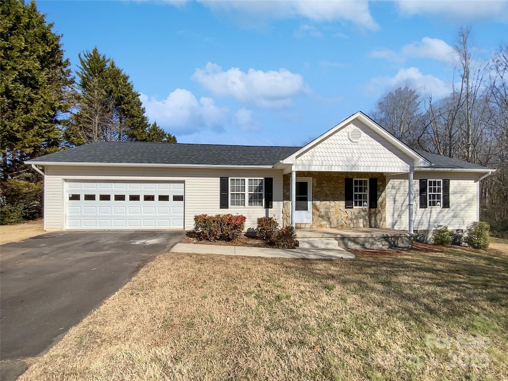 single story home with a porch, a garage, and a front yard