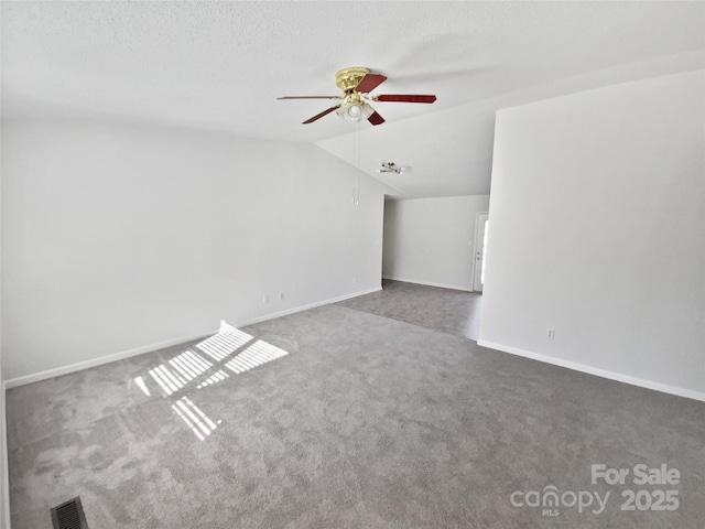 carpeted empty room featuring lofted ceiling, a textured ceiling, and ceiling fan