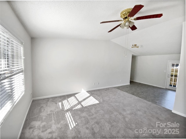 unfurnished room with ceiling fan, lofted ceiling, carpet floors, and a textured ceiling