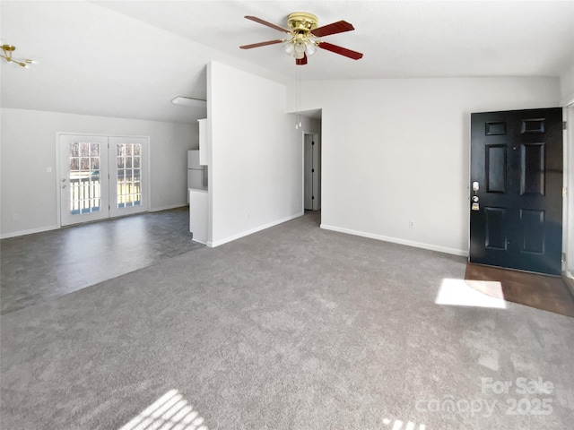 unfurnished living room with ceiling fan, lofted ceiling, and dark carpet