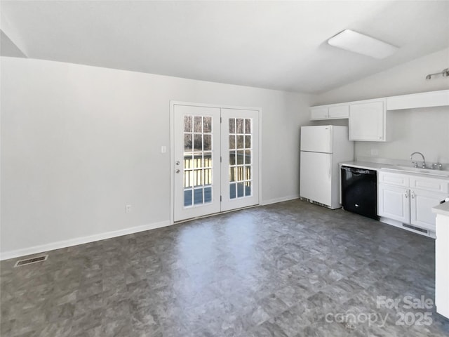 kitchen with sink, black dishwasher, white cabinets, vaulted ceiling, and white fridge