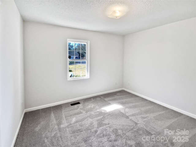 empty room with a textured ceiling and carpet