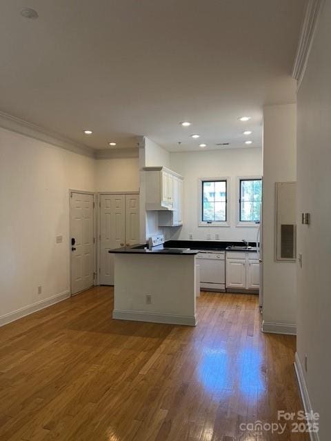 kitchen featuring white appliances, ornamental molding, white cabinets, and light wood-type flooring