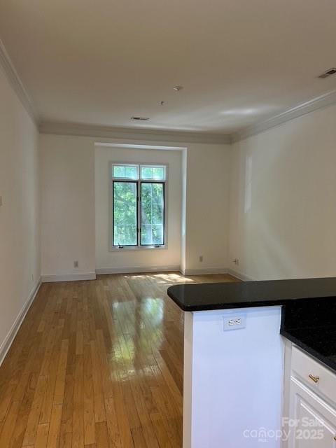 unfurnished room featuring crown molding and light hardwood / wood-style flooring