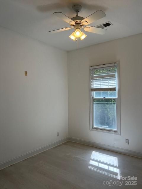 empty room featuring hardwood / wood-style floors and ceiling fan