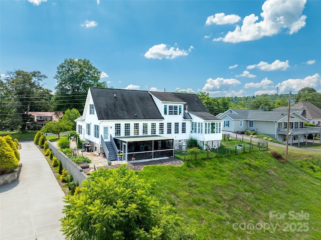 rear view of property featuring a sunroom