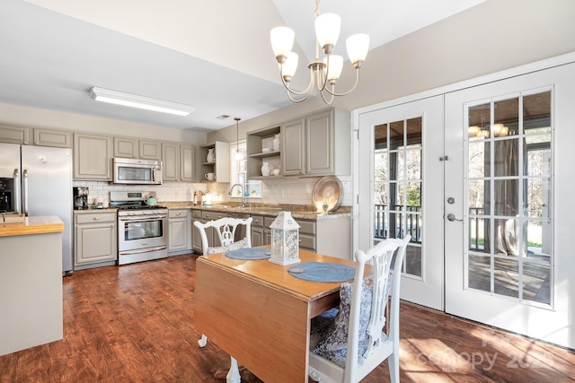 dining room with dark hardwood / wood-style flooring, sink, french doors, and an inviting chandelier