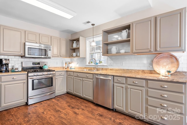 kitchen with dark wood-type flooring, sink, gray cabinetry, pendant lighting, and stainless steel appliances