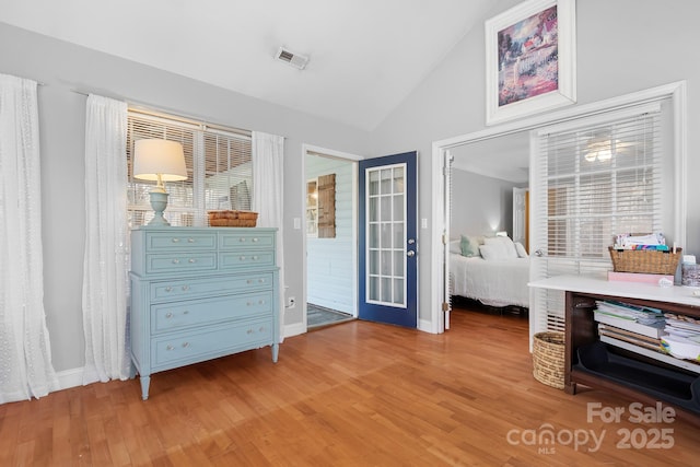 bedroom with hardwood / wood-style flooring, vaulted ceiling, and access to outside