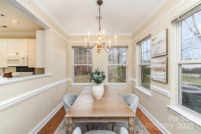 dining area featuring an inviting chandelier, hardwood / wood-style flooring, and ornamental molding