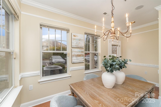 dining area with an inviting chandelier, crown molding, and hardwood / wood-style flooring