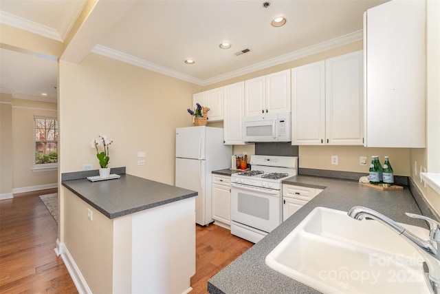 kitchen with white cabinetry, sink, white appliances, and kitchen peninsula