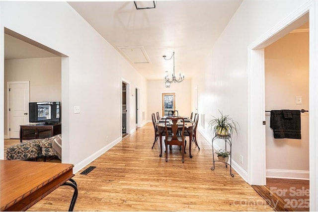 hall with light hardwood / wood-style flooring and a notable chandelier