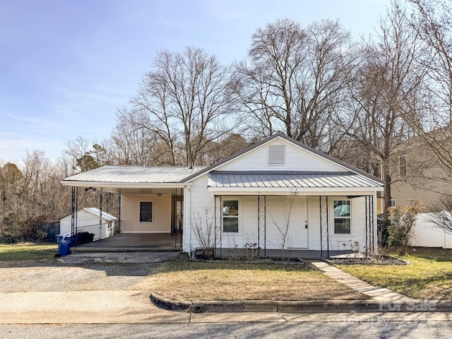 bungalow-style home with a carport and a front lawn