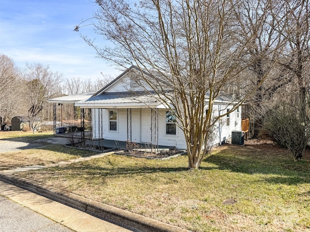 view of front of home with cooling unit, a front lawn, and covered porch