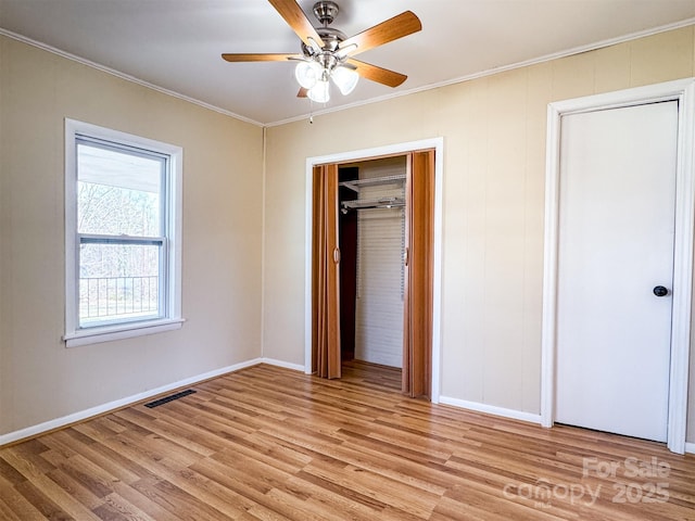 unfurnished bedroom featuring crown molding, light hardwood / wood-style floors, and ceiling fan