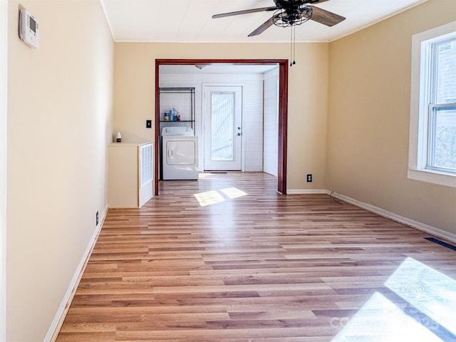 interior space with crown molding, washer / dryer, light hardwood / wood-style flooring, and ceiling fan