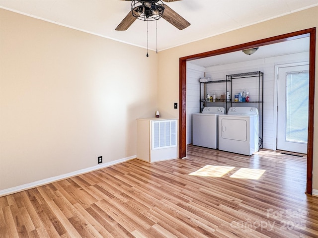 clothes washing area featuring crown molding, ceiling fan, washer and dryer, and light wood-type flooring