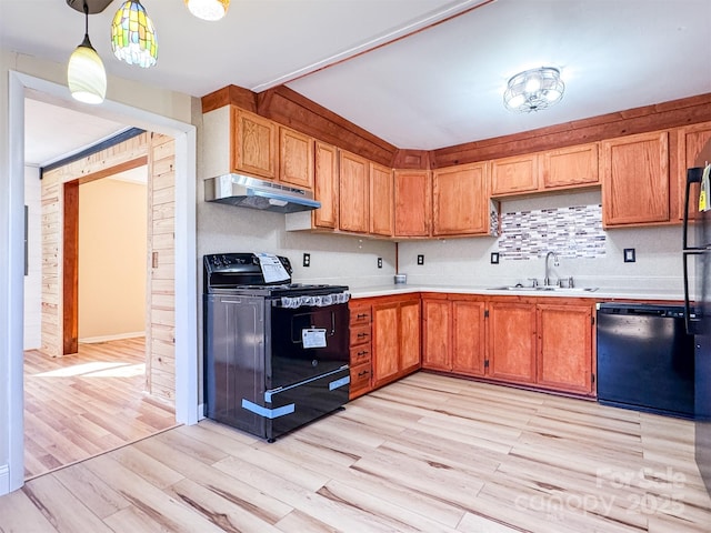 kitchen featuring pendant lighting, sink, light hardwood / wood-style flooring, and black appliances