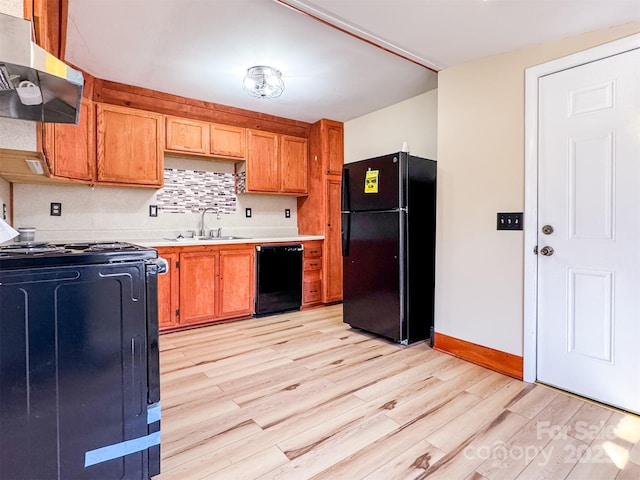 kitchen with sink, light hardwood / wood-style floors, and black appliances