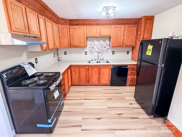 kitchen featuring sink, backsplash, black appliances, and light wood-type flooring