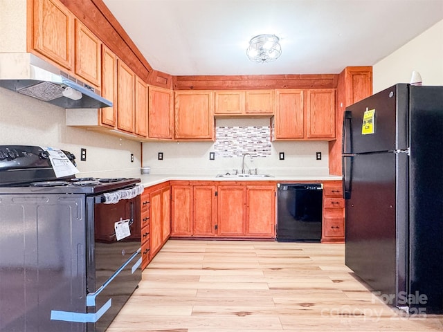 kitchen with sink, light hardwood / wood-style flooring, and black appliances