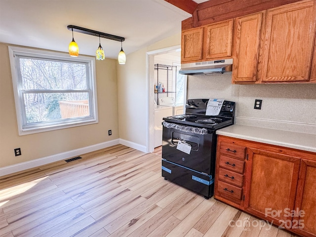 kitchen featuring hanging light fixtures, washer and dryer, black range with electric cooktop, vaulted ceiling, and light wood-type flooring