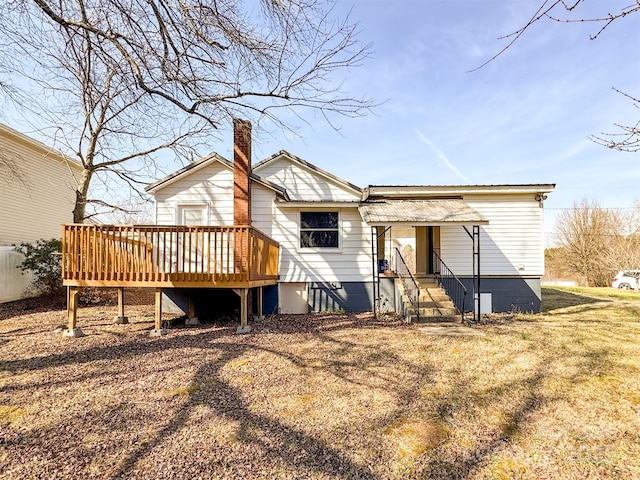 rear view of property featuring a yard and a deck