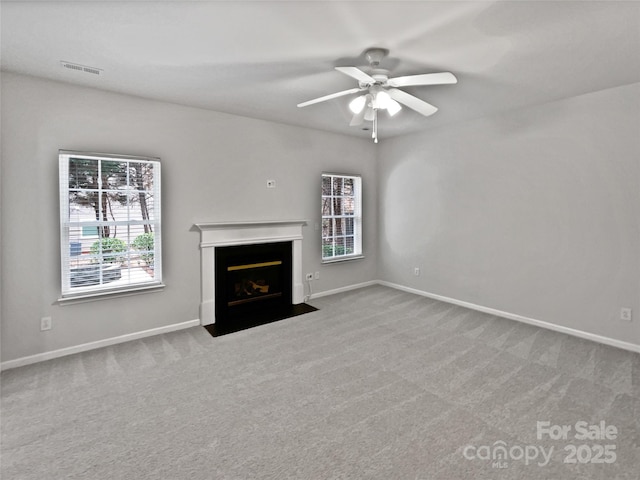 unfurnished living room with ceiling fan and carpet