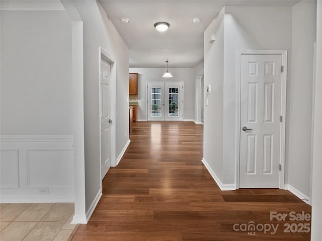 hallway with french doors and hardwood / wood-style floors