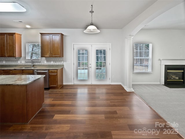 kitchen with sink, ornate columns, tasteful backsplash, dishwasher, and pendant lighting