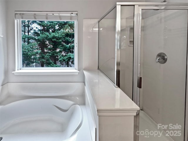 bathroom featuring shower with separate bathtub