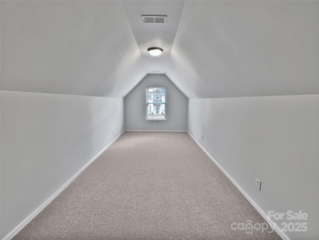 bonus room featuring light colored carpet and vaulted ceiling