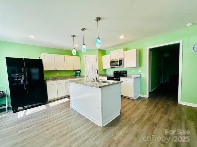 kitchen featuring sink, black appliances, an island with sink, white cabinets, and decorative light fixtures