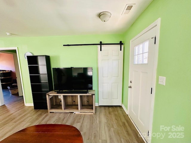 living room with wood-type flooring and a barn door