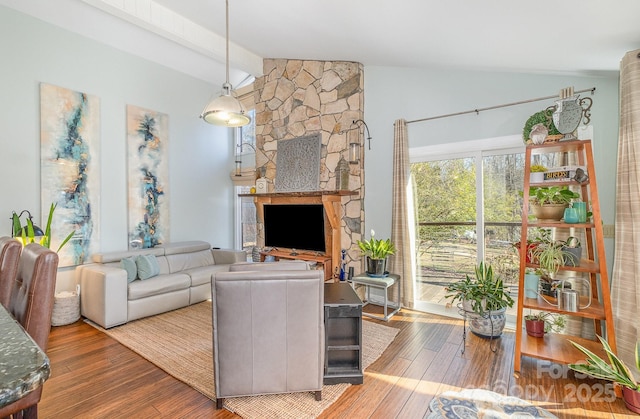 living area featuring lofted ceiling with beams and wood finished floors