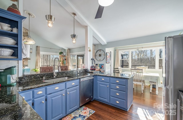 kitchen with a peninsula, blue cabinetry, appliances with stainless steel finishes, and open shelves