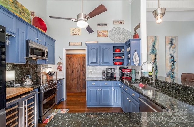 kitchen featuring open shelves, appliances with stainless steel finishes, a sink, and blue cabinets