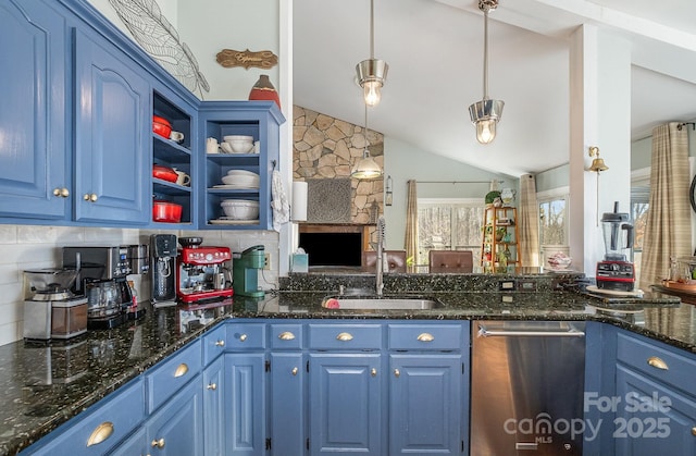 kitchen featuring dark stone counters, lofted ceiling, hanging light fixtures, blue cabinetry, and a sink