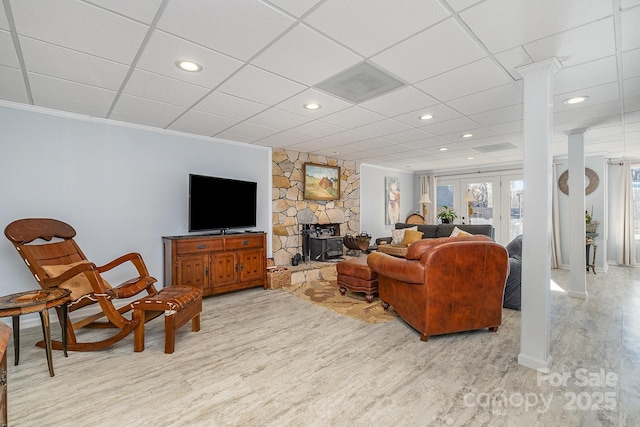 living area with a paneled ceiling, light wood-style flooring, recessed lighting, french doors, and decorative columns