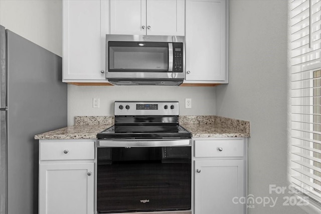 kitchen featuring white cabinetry, appliances with stainless steel finishes, and light stone counters