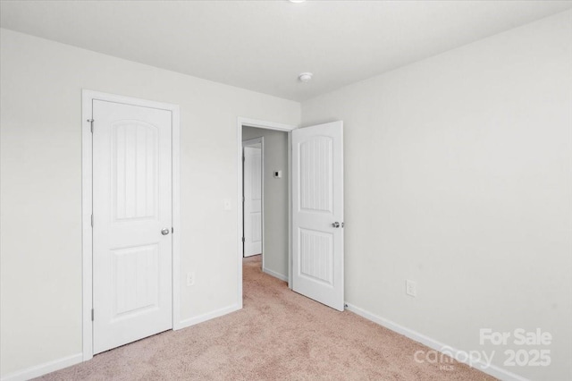 unfurnished bedroom with light colored carpet